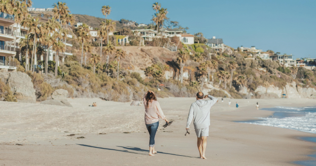 Pareja caminando playa viendo propiedades