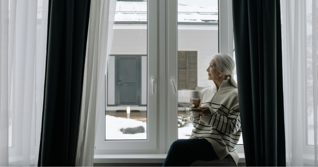 Dama mayor tomando cafe frente a ventana