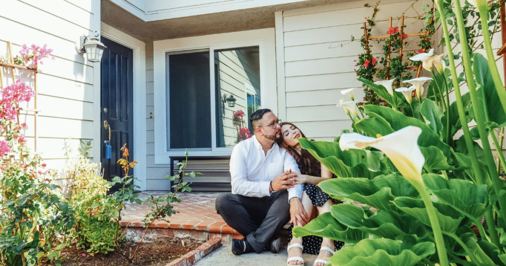 Pareja sentada en escaleras frente casa