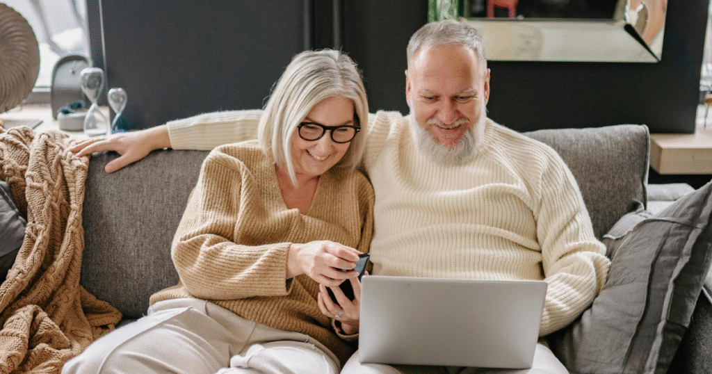 Adultos mayores sonriendo computadora